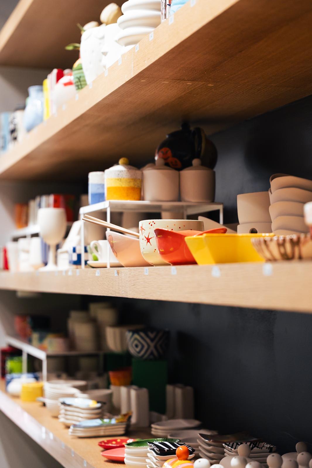 Colorful finished bowls, plates and keepsakes displayed on PotterMe studio shelves